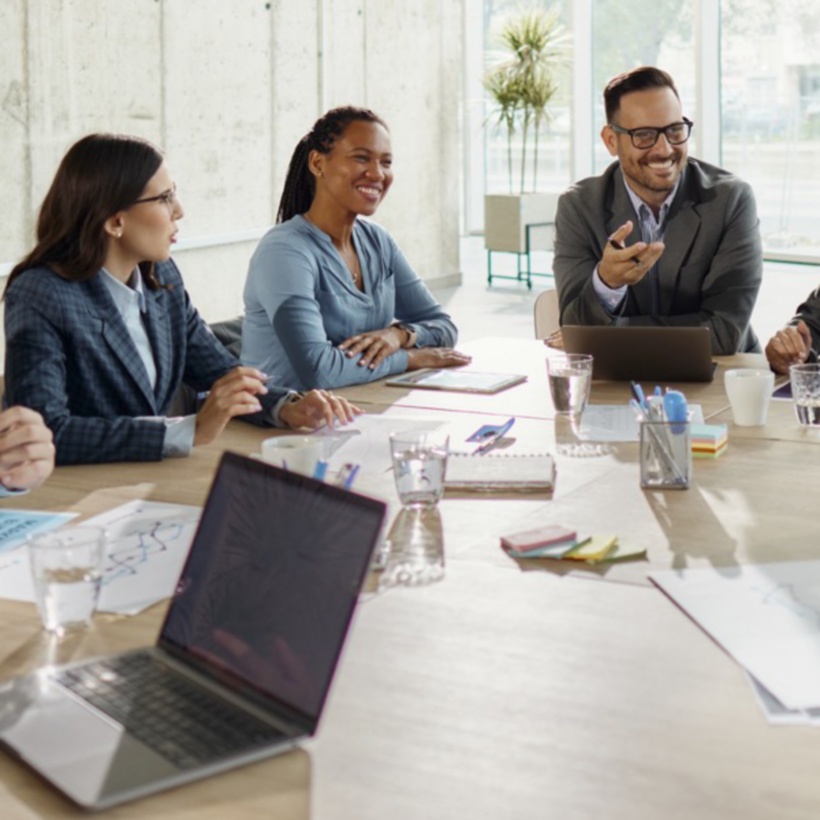 group of employees working around a conference room table