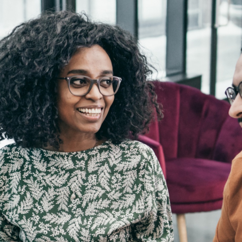 3 co-workers talking at a desk