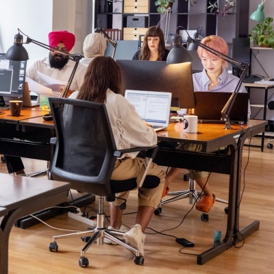 Employees working on laptops in an open office space.