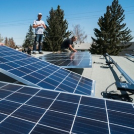 工人们在一个住宅屋顶上安装太阳能电池板。