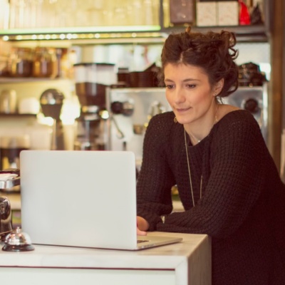 Owner of coffee shop using a laptop