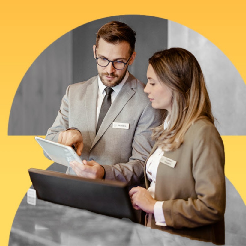 two hospitality employees working on a tablet together