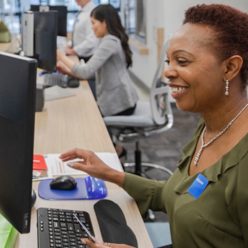 Banking employee assisting a customer at a bank teller desk