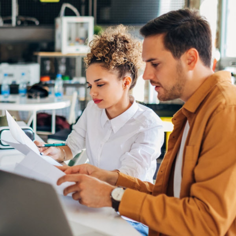 Colleagues working at a table in an open concept office space.