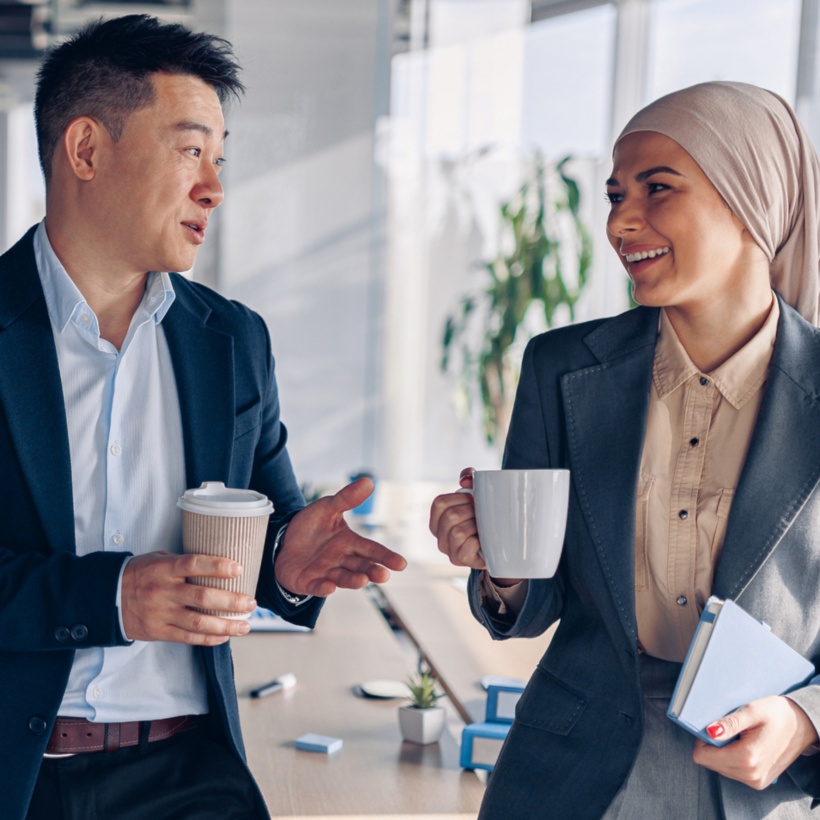 office workers in conference room talking and drinking coffee