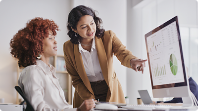 Two women looking at a computer monitor. 