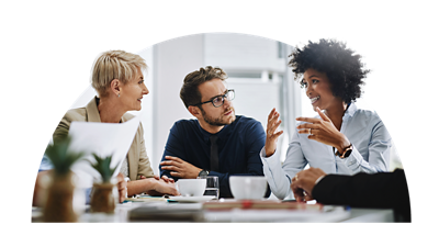 Three people sitting around a table talking.