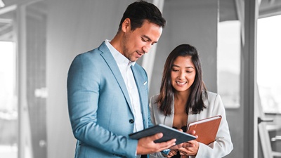 Man and woman looking at data on device.