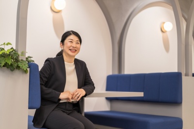 Workday のジャケットを着て、遠くを見ながら笑っている社員