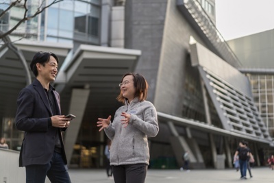 立って話をしている 1 人の社員と、座ってそれを聞いている大勢の社員