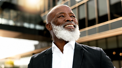 Man smiling and looking forward.