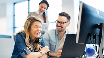 Image of people smiling at a desk.