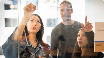 Group of employees ideating together at a whiteboard.