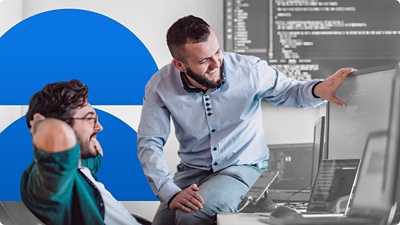 Two men viewing graphs on a screen.