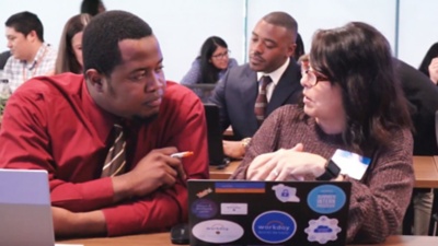 Two people collaborating in a meeting. 