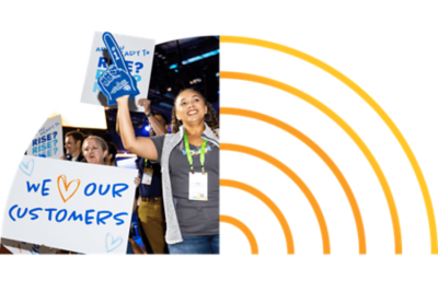 Energetic attendee holding up a hand drawn sign that reads “We love our customers”.