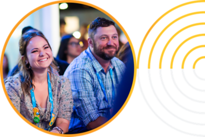 Two attendees listening to a presentation.