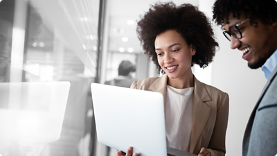 여성이 들고 있는 노트북을 보고 있는 여성과 남성