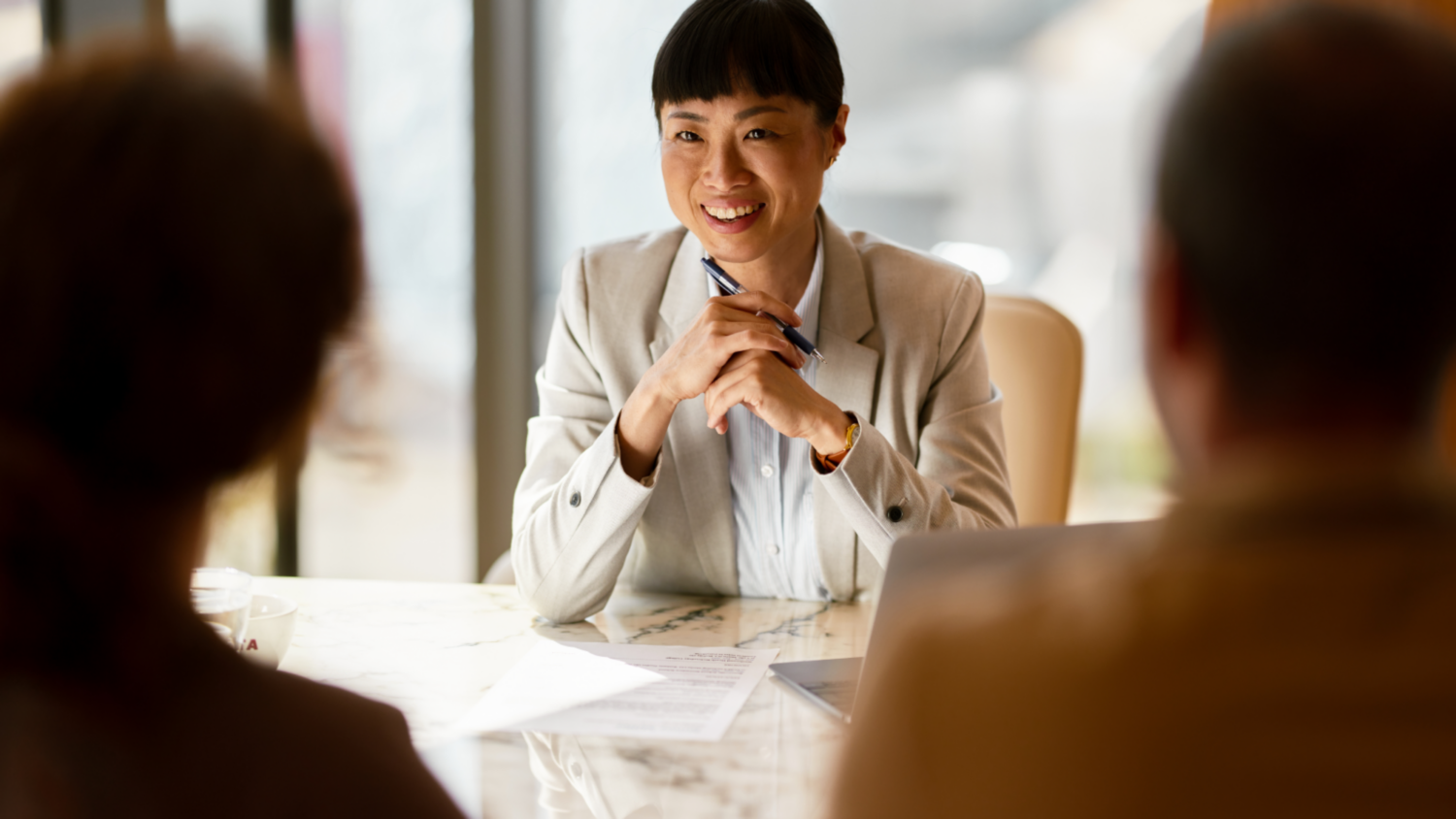 Woman Smiling At Stakeholders At Meeting