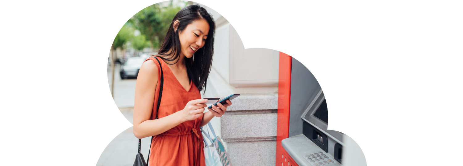 Woman taking the money from the ATM machine for shopping