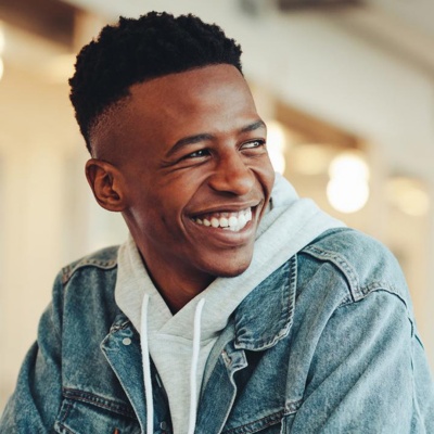 Male student sitting in classroom looking away and smiling