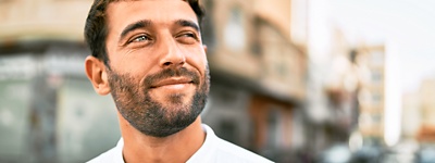 Man outside smirking and looking up