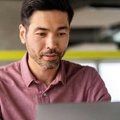 Employee at a desk working on a laptop.