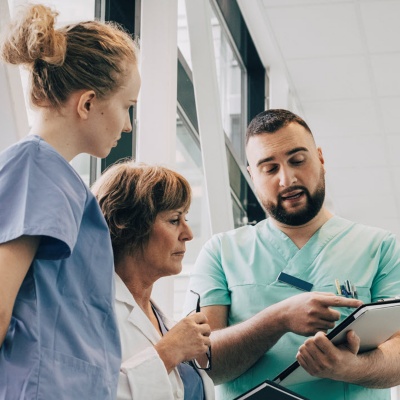 Group of clinicians reviewing information on a tablet together