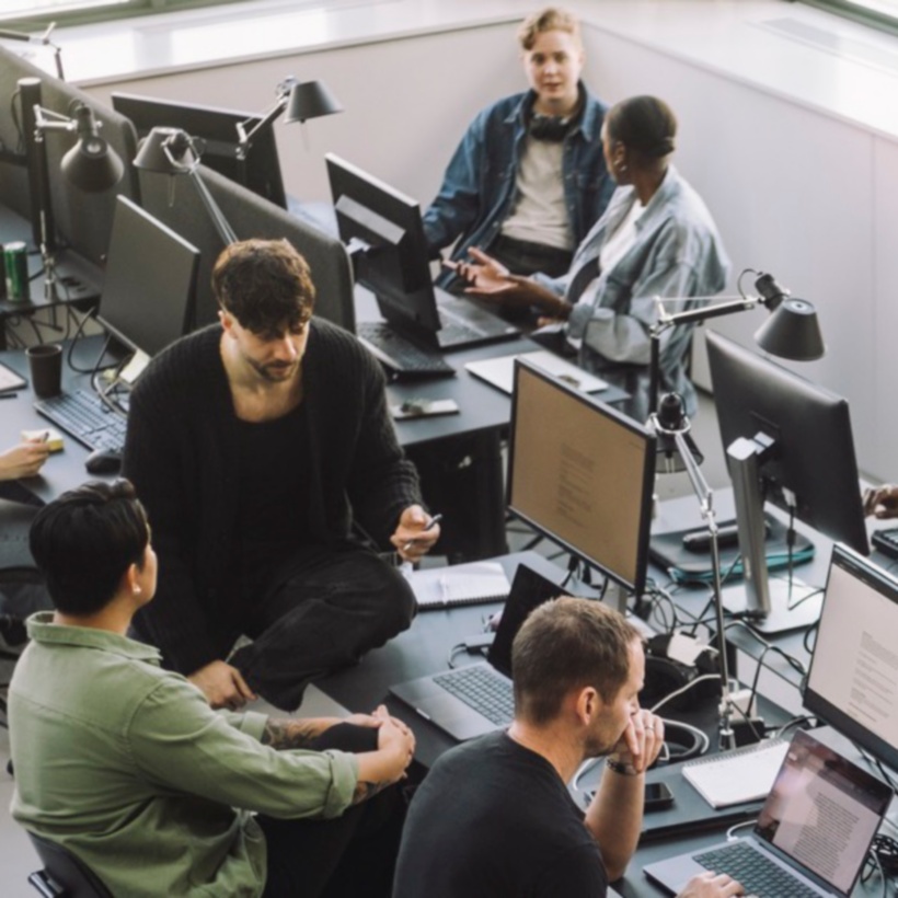 distant view of office workers working on computer at desks.