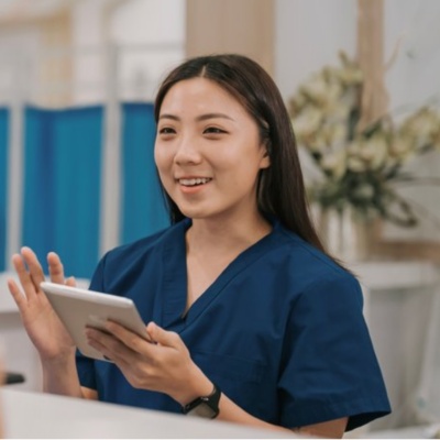 nurse at desk with tablet looking at family in doctor office