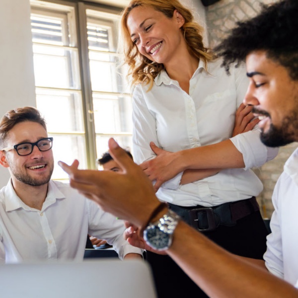 Group of office workers meeting in an open concept workplace.