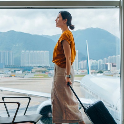 Person in an airport with a suitcase. 