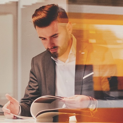 A man in a suit reading through a book of IT certifications