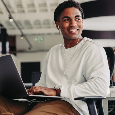 Student smiling while working on his laptop