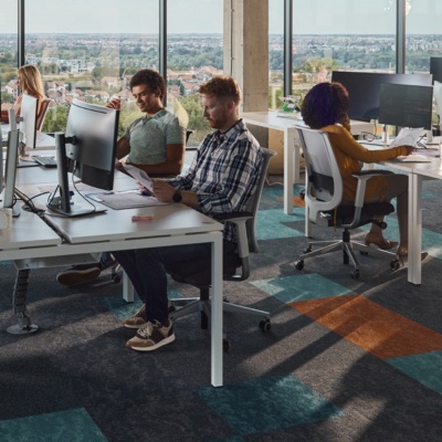 Large group of programmers working in a modern office of a software company. 