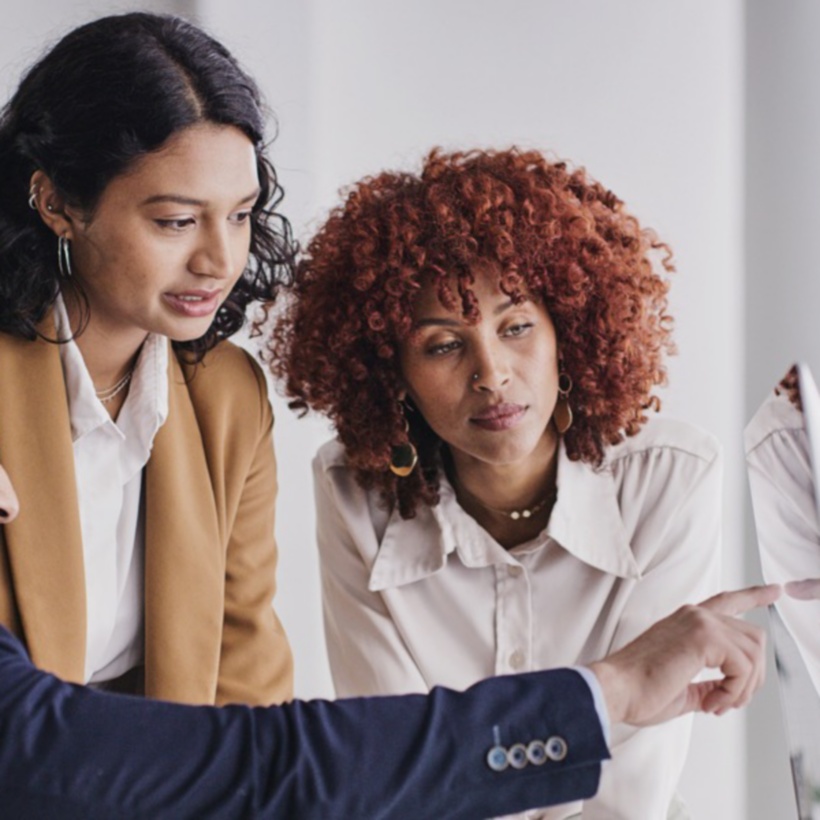 three professional colleagues looking at a computer screen