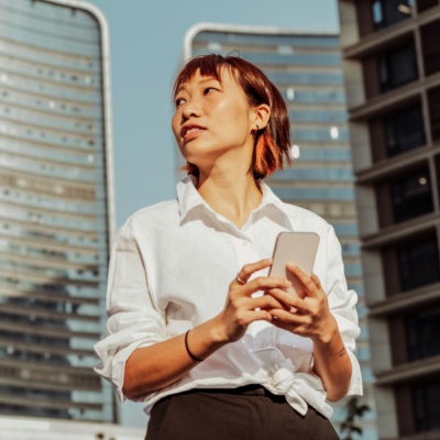 woman-on-smartphone-in-front-of-building Bild für Blogpost: Das Ende des Jobprofils: Warum KI es überflüssig macht – und was als Nächstes kommt