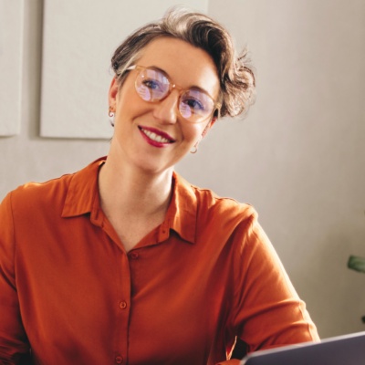 Woman with short hair and glasses looking at person