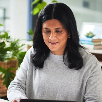 Employee working on a tablet and laptop at a desk